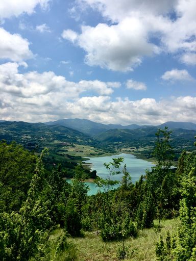 A vertical shot of the beautiful lake surrounded by green hills. Serbia.
