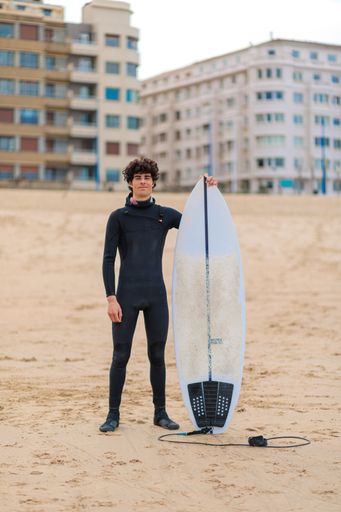 A Caucasian male surfer getting ready to go surfing in the ocean