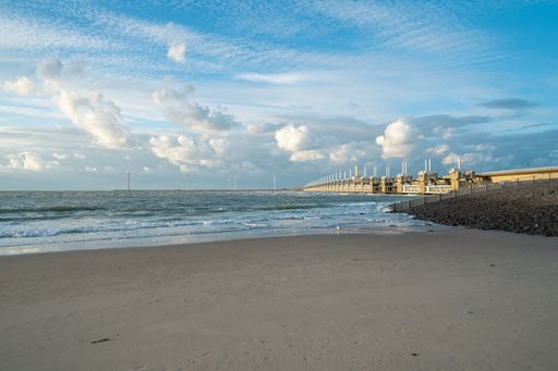 The wavy ocean hitting the sandy beach under the cloudy sky - great for wallpapers