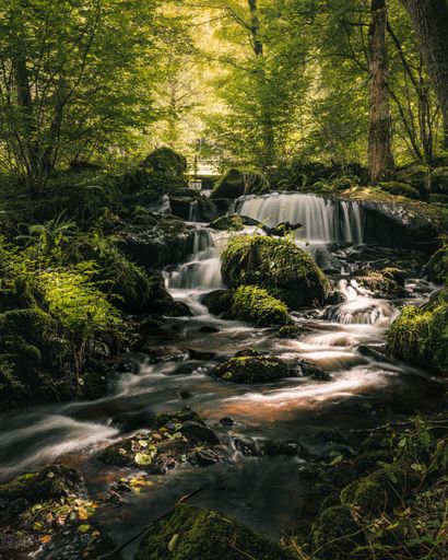 A vertical shot of a waterfall in the forest, Czech Republic