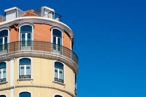 A low angle shot of a tall building with windows under a clear sky in Lisbon, Portugal