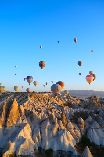 A vertical shot of a bunch of hot air balloons in the sky over Cappadocia, Turkey
