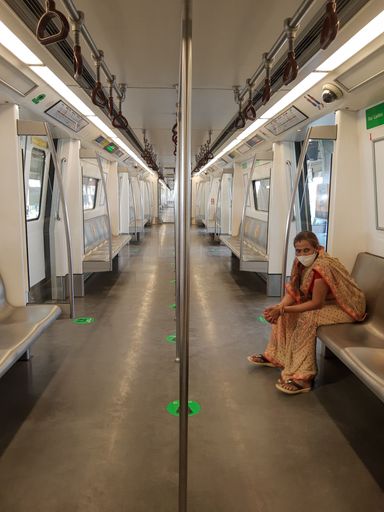 A vertical shot of a female wearing a mask while travelling on metro