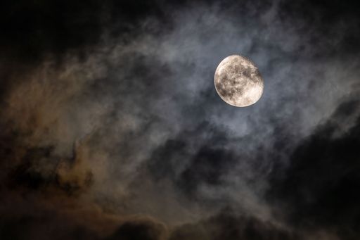 A beautiful bright full moon in a cloudy night sky