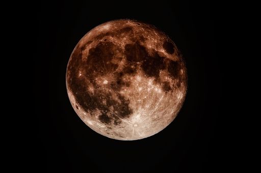A beautiful sparkling round orange moon in a black night sky