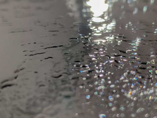 A closeup shot of raindrops falling in the water