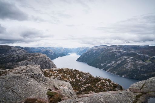 A scenic shot of cliffs along Rock creek under the gloomy clouds in Pulpit Rock, Norway