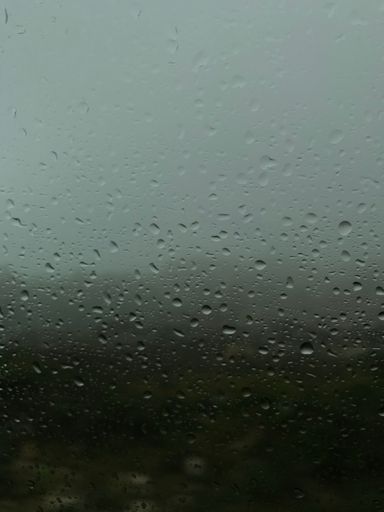The vertical view of raindrops on the glass creates a relaxing background