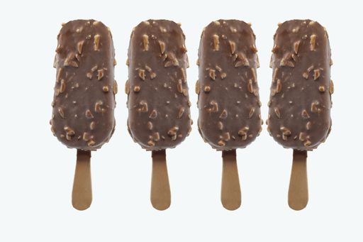 A closeup of ice cream with nut and chocolate topping isolated on a white background