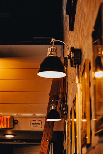 A vertical shot of shiny photo frames and wall lights illuminating the place