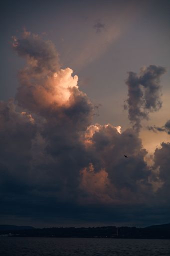 A vertical shot of the big clouds in the golden sunset sky for a wallpaper or a background