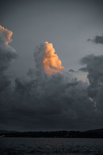 A vertical shot of the big clouds in the golden sunset sky for a wallpaper or a background