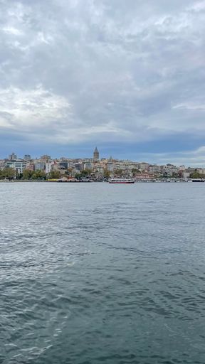 A landscape of harbor in the sea under cloudy sky and the coast on the horizon, vertical shot