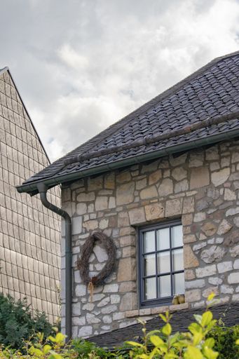 A vertical shot of a facade of a house under cloudy sky