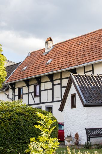 A vertical shot of a facade of a house under cloudy sky