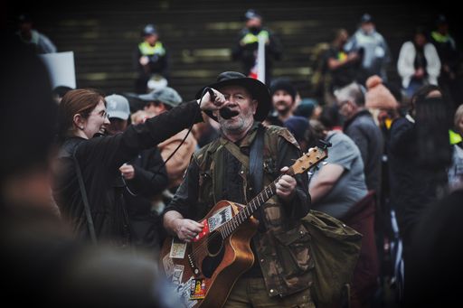 A guitar player performing in a freedom protest in Melbourne