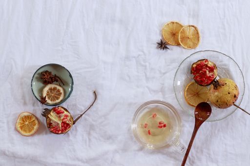 Overhead view of pomegranate fruit and dried lemon slices for making fresh juice, showing an autumn theme aesthetic background