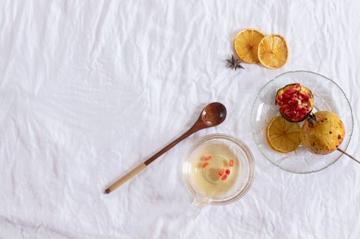 Overhead view of pomegranate fruit and dried lemon slices for making fresh juice, showing an autumn theme aesthetic background
