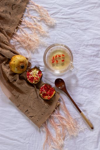 Vertical flat lay of pomegranate fruit with dried lemon slices for making fresh juice that shows autumn themed aesthetic