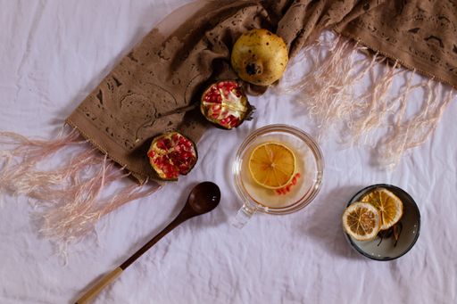 Overhead view of pomegranate fruit and dried lemon slices for making fresh juice that shows autumn themed aesthetic