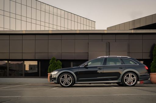 A beautiful black car parked near a modern building