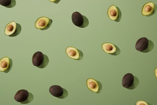 A top shot of the sliced avocados on a green background
