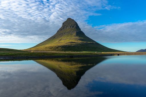 A beautiful view of Mount Kirkjufell with reflection on a tranquil lake in Iceland