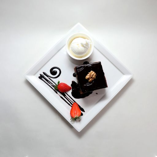 A top view of a piece of chocolate cake on a plate isolated on a white background