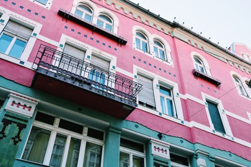A low angle shot of a bright pink building