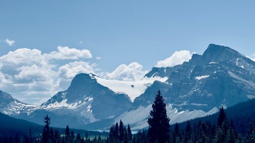 A beautiful shot of rough mountains partly covered in snow