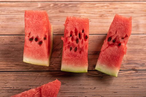 A top view of red juicy delicious watermelon slices on wooden table