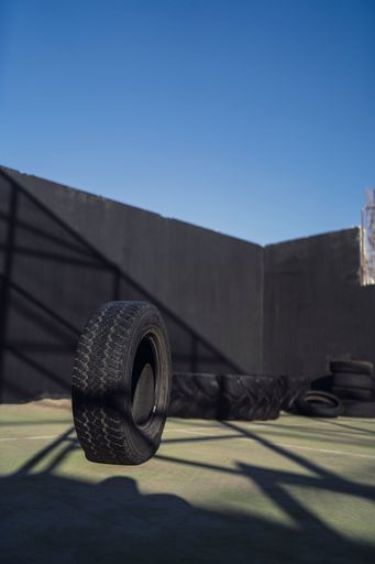 A vertical shot of an outdoor gym with tires on a sunny day