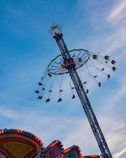 Vertical shot of a carousel at Munichs famous Oktoberfest with blue sky, Munich, Germany