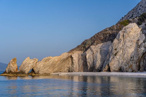 A breathtaking shot of the calm sea and rocky Lalaria beach during sunset, Skiathos island Greece-perfect for wallpaper