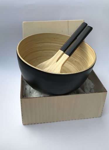 A closeup of a wooden gift box with a bowl and spoons on white background