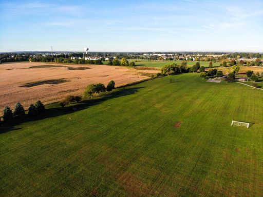 An aerial view of green farmland at a soft warm sunlight