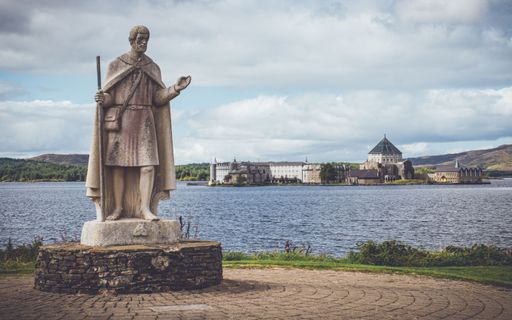 An aerial view of statue in background of Saint Patrick Purgatory church in Donegal