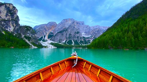 A landscape view of the lake surrounded by trees and mountains