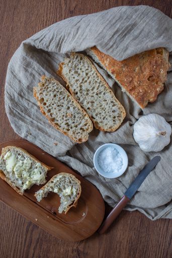 A closeup of delicious no knead bread on a towel on a wooden table