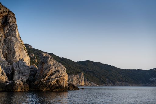 A breathtaking shot of the calm sea and rocky shore during sunset, Naxos island Greece-perfect for wallpaper