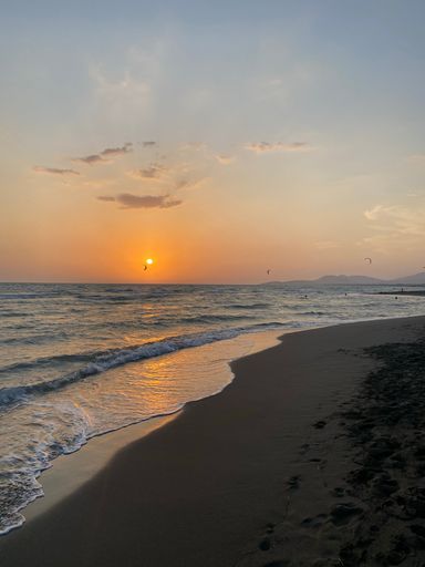 A vertical shot of an idyllic sandy beach at sunset