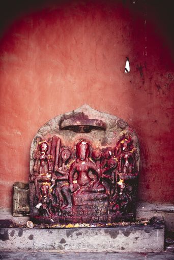 A vertical closeup shot of sculpting with a red wall in the background