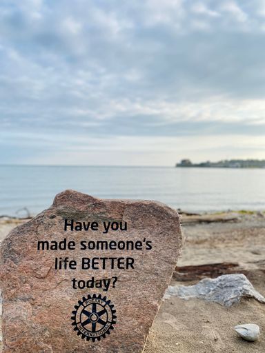 A vertical shot of a stone with a writing on the beach of Ontario lake in Toronto, Canada