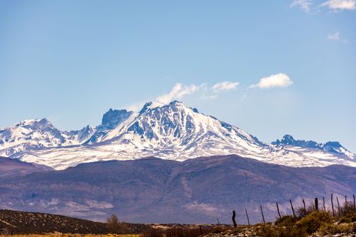 The view of a snow-covered peak of the Andes mountain range under the blue sky in  Mendoza
