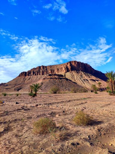 A beautiful landscape of a rocky mountain raising above a desert on a sunny day