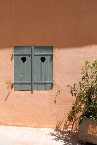 A vertical shot of cozy wooden window with hearts of an old building