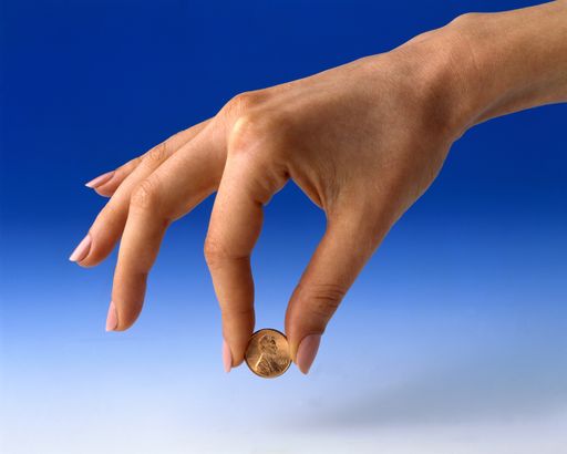 A closeup shot of a female holding a small coin on blue background