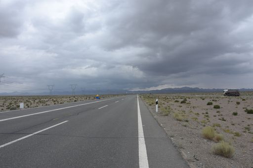 A scenic shot of an empty asphalt road against the cloudy sky
