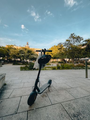 A vertical shot of an electric scooter parked in the park