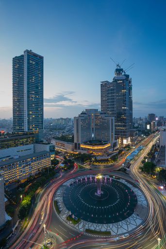 An aerial view of cityscape Jakarta surrounded by buildings with light trails